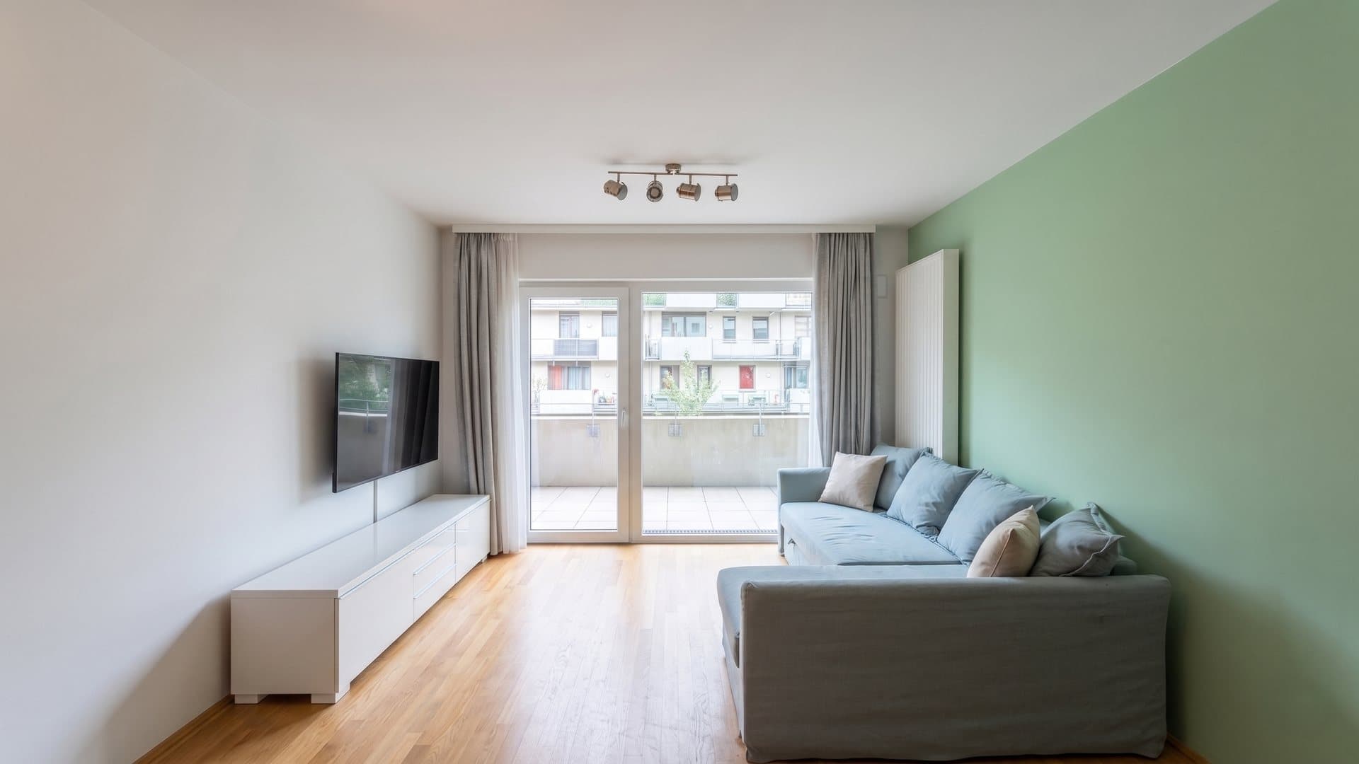 Bright living room with parquet flooring and access to the loggia — family flat in Seestadt Aspern